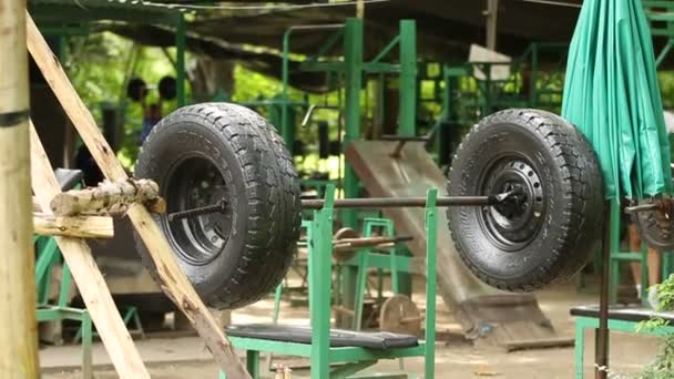 泰国曼谷-2012 年 10 月 24 日。在户外临时健身房用一只手作体育酒吧的轮胎机。隆比尼公园. — 图库视频影像