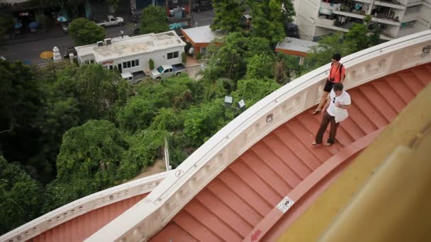 BANGKOK, TAILANDIA - 25 de octubre de 2012. Dos cámaras de crecimiento de turistas bajan las escaleras en Wat Saket Golden Mount. Bangkok, Tailandia . — Vídeos de Stock