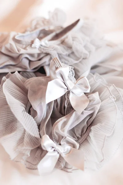Menyasszonyi harisnyakötő. Menyasszony hagyományos szimbolikus tartozék. Szürke csipkék íjjal. Közelről. — Stock Fotó