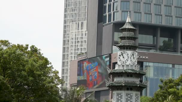 Bangkok, Thailand - oktober 20, 2012. Pagoda stylad klocktornet i Lumpini park. Moderna skyskrapor på bakgrund. — Stockvideo