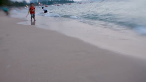 Pattaya, Tayland - 30 Eylül 2012. Deniz sörf. Dalgalar kum üzerinde oynayan çocuklar ayak izleri silmek. Lens bebek tatlı 35mm ile shooted — Stok video