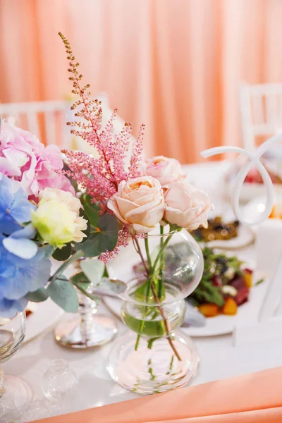 Tavola apparecchiata per banchetto nuziale con composizione floreale di rose e astilbe. Decorazione floreale in vaso . — Foto Stock