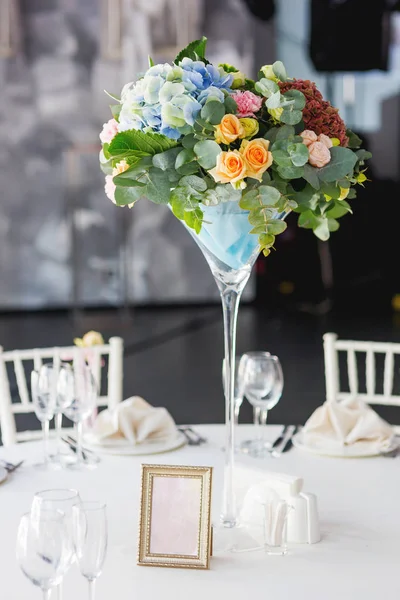 Set da tavola per banchetto di nozze con composizione floreale di rose e ortensie. Decorazione floreale in vaso alto . — Foto Stock