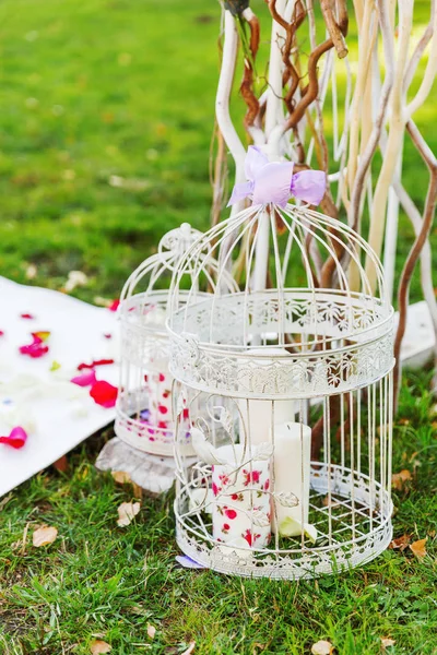 結婚式のための美しい花のアーチの詳細。アジサイとバラの曲がった棒から成っています。地面の上のろうそくが付いている装飾的なおり。結婚式は公園で屋外を設定. — ストック写真