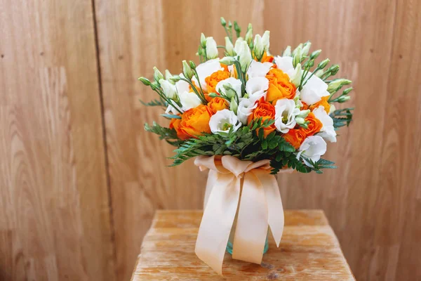 Ramo de boda sobre fondo de madera en mal estado. El accesorio simbólico tradicional de la novia. Composición floral con eustoma (o Lisianthus) y rosas naranjas . — Foto de Stock