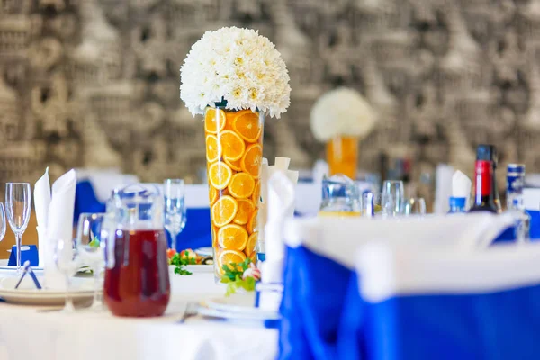 Tablo için düğün Ziyafet çatal ile ayarla. Salatalar, mezeler ve gözlük şarap ile. Dekorasyon öğeleri - portakal dilimleri ve beyaz papatya çiçek vazolar.