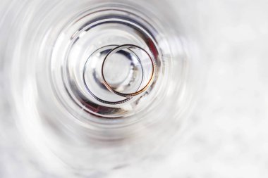 Düğün altın şeffaf cam halkalar. Aşk ve evlilik sembolü. Güneş ışığında ışıltılı cam ile yaratıcı resim.