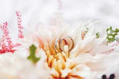 Altın alyans çifti gelin buketi çiçek içinde yatıyor. Aşk ve evlilik sembolü. Gelin için geleneksel çiçek Aksesuar.