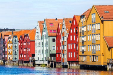Famous wooden colored houses in Trondheim city, Norway. Colorful houses on stilts in sunny day. clipart