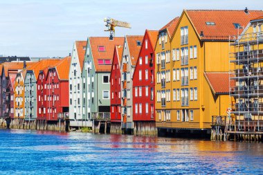 Famous wooden colored houses in Trondheim city, Norway. Colorful houses on stilts in sunny day. clipart