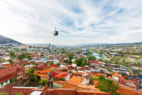 Vista panorámica de Tiflis, capital del país de Georgia. Vista desde la fortaleza de Narikala. Carretera de cable sobre techos alicatados . — Foto de Stock
