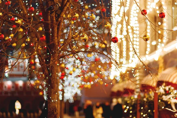 Straten van Moskou ingericht voor Nieuwjaar en Kerstmis viering. Boom met heldere rode en gele ballen. Gebouwen met lampen. Rusland. — Stockfoto