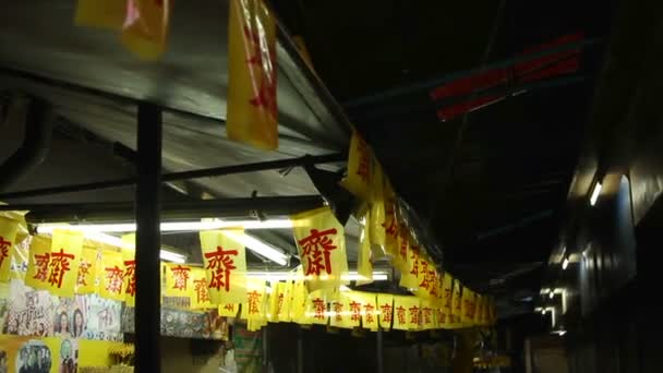 BANGKOK, TAILANDIA - 20 de octubre de 2012. Ciudad por la noche. Tiendas cerradas con banderas de jeroglíficos de color amarillo brillante y carteles . — Vídeo de stock