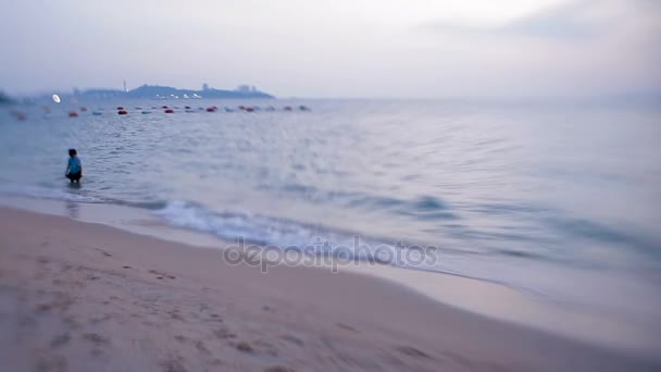 Surf marino. Las olas borran las huellas de los niños en la arena. Pattaya, Tailandia. Disparo con lente bebé dulce 35mm — Vídeo de stock