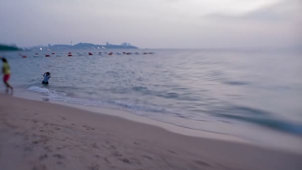 PATTAYA, TAILANDIA - 30 de octubre de 2012. Niño bañándose en el mar. Las olas borran las huellas de los niños jugando en la arena. Disparo con lente bebé dulce 35mm — Vídeos de Stock