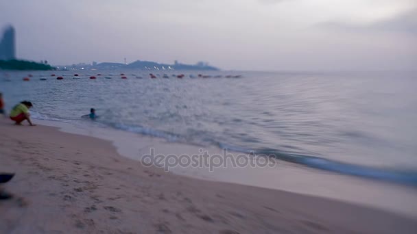Pattaya, Tajlandia - 30 października 2012 r. Dziecko kąpieli w morzu. Fale wymazać gry dzieci ślady stóp na piasku. Klocki z Sweet Baby obiektywu 35mm — Wideo stockowe