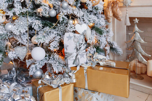 Рождественский и новогодний фон с подарками под Евой. Зимний отдых фон. Много подарков, завернутых в золотую и серебряную бумагу с луками
.