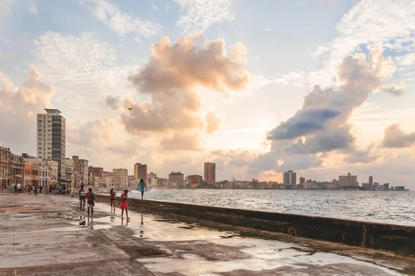 HAVANA, CUBA - 10 febbraio 2008. La gente incontra tramonto dopo tempesta al famoso lungomare Malecon . — Foto Stock