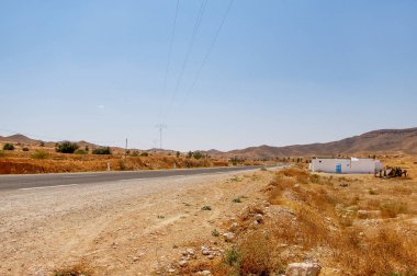 Yolda bir yerde Tunus Sahara çöl yoluyla. Afrika, yatay, güç hatları ve asfalt yol.