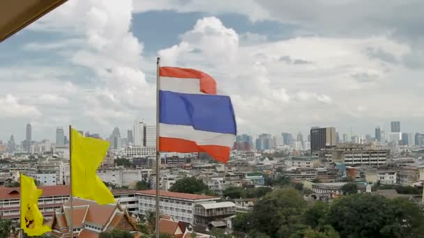 Thailand state flag fluttering in the wind on the top of Wat Saket Golden Mountain . Bangkok panorama view on background. Thailand. — Stock Video