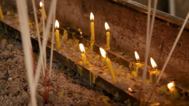 Náboženské žluté svíčky a aromasticks. Wat Saket, Bangkok, Thajsko. — Stock video