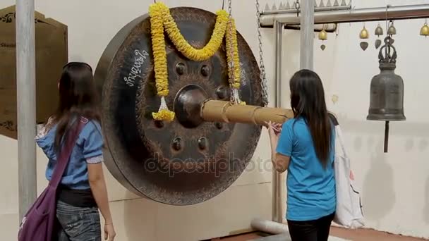 BANGKOK, THAILAND - October 24, 2012. Tourists beat sacral gong in Wat Saket Ratcha Wora Maha Wihan the Golden Mount . — Stock Video