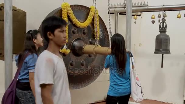 BANGKOK, TAILANDIA - 24 de octubre de 2012. Turistas golpean gong sacro en Wat Saket Ratcha Wora Maha Wihan el Monte Dorado  . — Vídeos de Stock