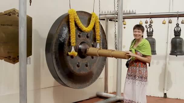 BANGKOK, THAILAND - October 24, 2012. Tourists beat sacral gong in Wat Saket Ratcha Wora Maha Wihan the Golden Mount . — Stock Video