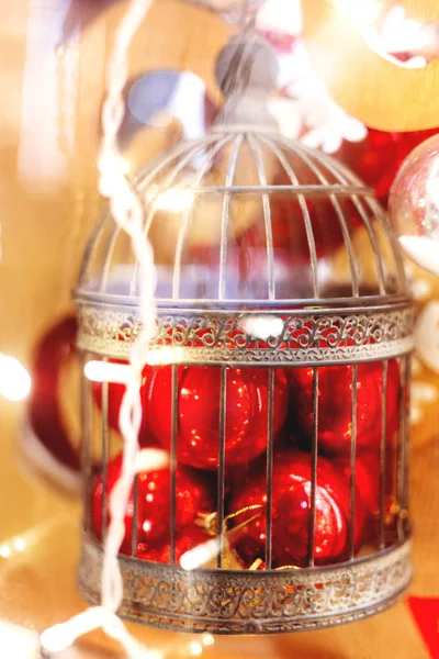 Kerstmis en Nieuwjaar achtergrond met lichte decoratieve ballen in de oude ouderwetse decoratieve vogelkooi. Decoraties voor de viering van de vakantie. — Stockfoto