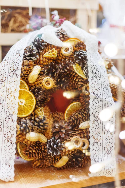 Corona de Navidad hecha con conos de pino y abeto, naranjas secas, cacahuetes y rosquillas al horno. Decoración de Año Nuevo hecha a mano con lazo de encaje . — Foto de Stock