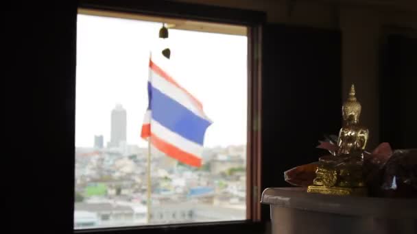 Estatua dorada de Buddha.Bandera del estado de Tailandia ondeando en el viento en la parte superior del Wat Saket Golden Mount. Vista panorámica de Bangkok sobre fondo. Tailandia . — Vídeo de stock