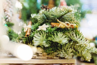Yapılan çam ve köknar dalları, tarçın ve ahşap yıldız ile Noel çelenk. El yapımı yılbaşı dekorasyon ampuller ile.
