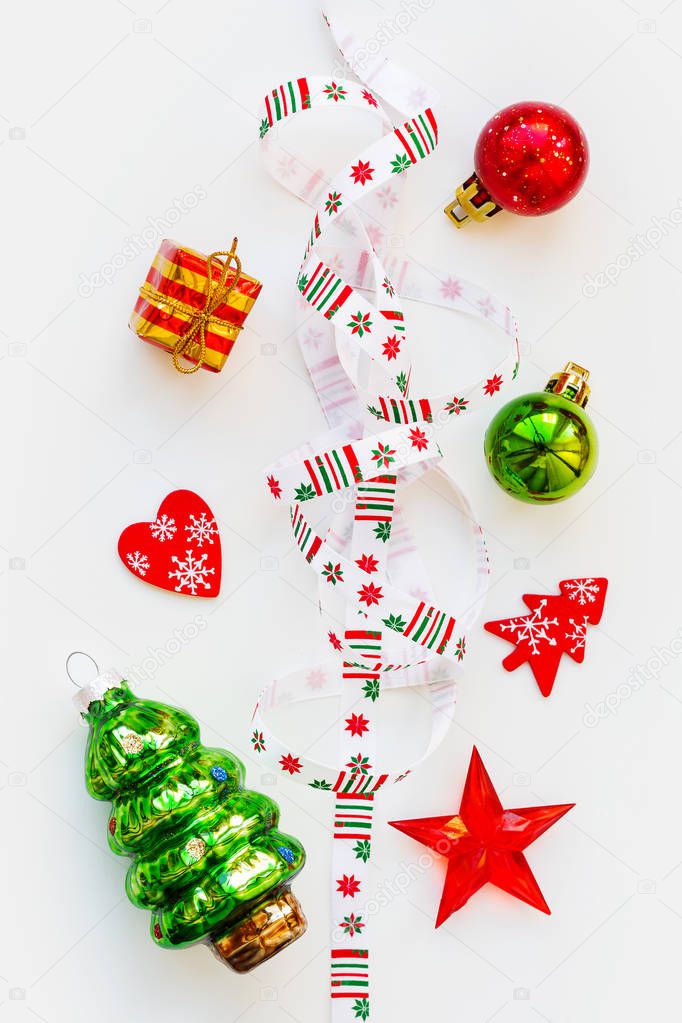 Ribbon with Christmas pattern - nordic geometric snowflakes. New Year decorations - bright colorful balls, fir tree, star. Flat lay, top view.