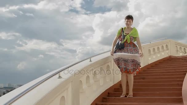 БАНГКОК, ТАИЛАНД - 24 октября 2012 года. Женщина, остановившаяся на лестнице Ват Сакет. Платье развевается на ветру, очень жаркий день . — стоковое видео