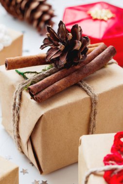 Noel ve yeni yıl arka plan sunar ve süslemeleri ile. El yapımı Hediyelik çam kozalağı ve tarçın ile Kraft kağıt sarılı.