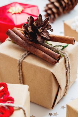 Noel ve yeni yıl arka plan sunar ve süslemeleri ile. El yapımı Hediyelik çam kozalağı ve tarçın ile Kraft kağıt sarılı.