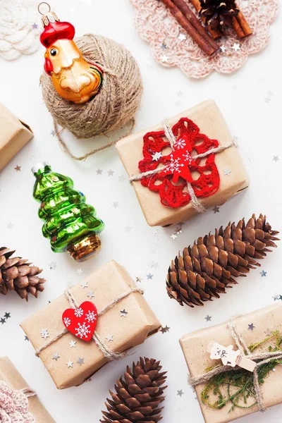Kézzel készített ajándékok karácsonyi és újévi háttér csomagolva papír kézműves és a dekoráció, holiday szimbólumok. — Stock Fotó