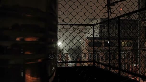 Nachtregen in Bangkok. Blick auf nasse Straße vom Balkon durch Rabitznetz. Thailand. — Stockvideo