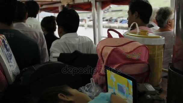 Bangkok, Thailand - 24 oktober 2012. skara människor flytta båt, kollektivtrafik på Chao Praya floden. Barn titta på TV på netbook. — Stockvideo