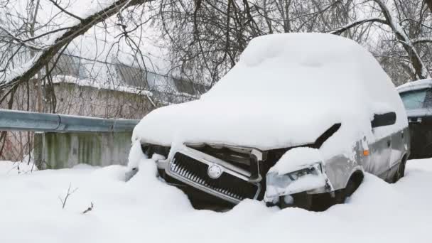 Oude gebroken auto onder de sneeuw. Verlaten auto. — Stockvideo