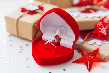 Nişan yüzüğü ve hediyeler, Noel ağacı süslemeleri ile Noel ve yeni yıl arka plan. Tatil yıldız konfeti ve ampul arka plan. Metin için yer.