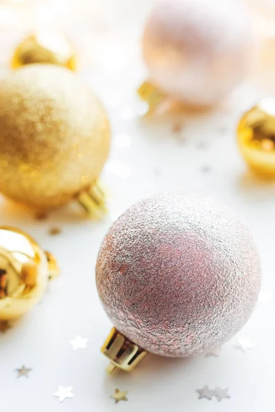 Vánoce a nový rok pozadí s zlaté ozdobné koule na vánoční stromeček s žárovky a konfety. — Stock fotografie