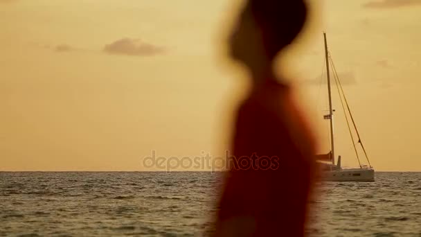 Puesta de sol en la playa de Naiharn. El yate de vela se balancea sobre las olas. Paisaje nublado sobre fondo naranja al atardecer . — Vídeos de Stock