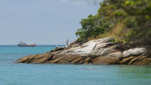 PHUKET, TAILANDIA - 18 de noviembre de 2012. Hombres pescando en la orilla. Barco de pesca balanceándose sobre las olas . — Vídeos de Stock