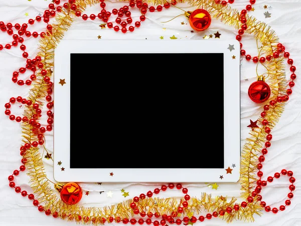 Tableta sobre fondo de vacaciones de invierno. Adornos de Navidad - rojo — Foto de Stock