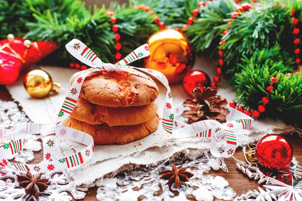 Weihnachten und Neujahr Hintergrund mit Dekorationen, Tannenzapfen und Stapel von leckeren Plätzchen mit Feiertagsband. — Stockfoto