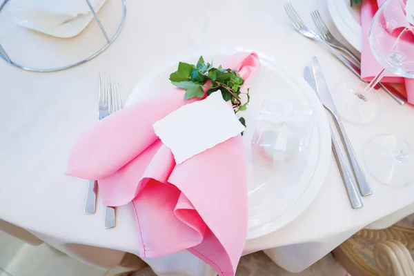 Tavola apparecchiata per banchetto di nozze con posate. Ivy lascia la decorazione. Biscotto di maccheroni in scatola regalo come regalo agli ospiti da sposa e sposo . — Foto Stock