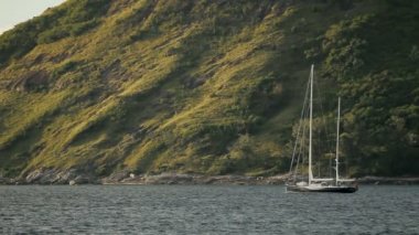 Yelkenli yat dalgalar üzerinde sways. Phuket Island, Tayland Naiharn kumsalda.