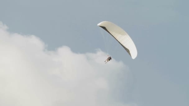 ПЮКЕТ, ТАЙЛАНД - 22 ноября 2012 г. Человек летит на параплане над ветряной мельницей на острове Пкутет, Таиланд . — стоковое видео