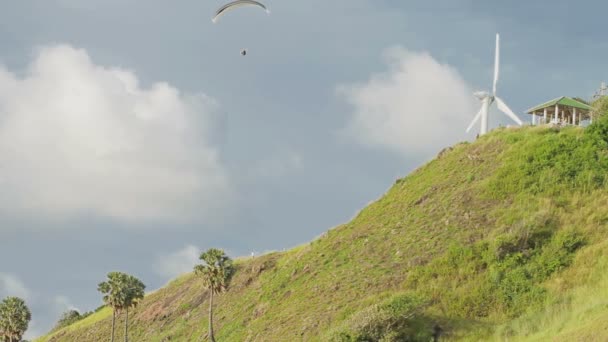 Muž na kluzák létání nad hlediska větrný mlýn na Pkutet ostrově, Thajsko. — Stock video